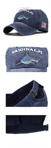 Macro shot of embroidered shark detail and American flag patch on washed denim baseball cap