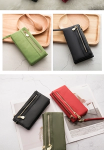 Multi-color long wallets with gold zipper pocket and wrist strap on a wooden tray