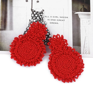 Detail of red beaded earrings showing intricate handmade beadwork craftsmanship