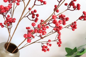 Dettaglio di rami con bacche rosse artificiali in vaso per decorazioni di interni