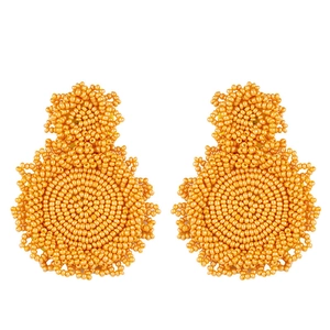 Detail of bohemian orange seed bead earrings with handmade woven circular design