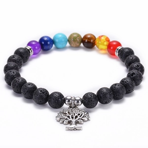 Macro detail of lava rock beads and seven chakra stones with a tree of life charm