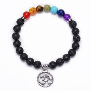 Macro shot of natural lava rock beads and Om symbol pendant on the chakra bracelet