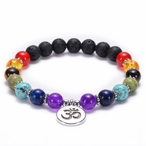 Close-up of 7 chakra lava stone bracelet showing colorful beads and silver Om charm