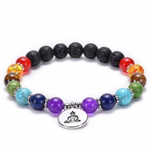 Macro shot of 7 chakra bead bracelet with lava stones and silver Buddha charm detail