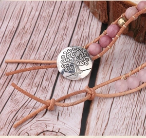 Detail of bohemian wrap bracelet with pink natural stones and tree of life metal clasp