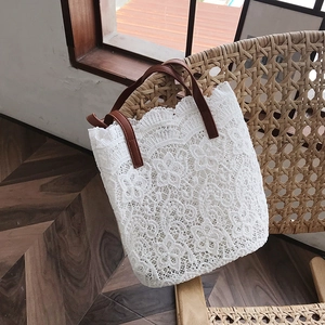 Detailed macro view of intricate floral lace patterns on a large white bucket tote bag
