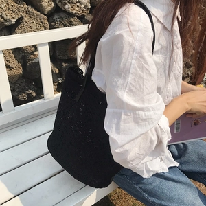 French style black crochet lace tote bag shown in a casual outdoor lifestyle setting