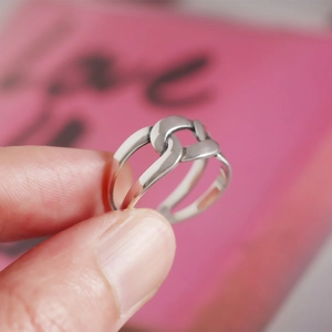 Detailed close-up of a minimalist S925 sterling silver woven double ring design