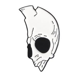 Detail view of a stylized black and white skull enamel pin with polished metal finish