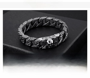 Macro detail of men's stainless steel skull bracelet with heavy scale link and buckle