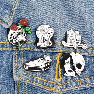 Close-up of gothic skeleton and coffin enamel pins on a denim jacket pocket