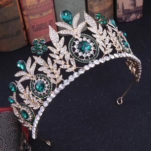 Detailed close-up of golden bridal crown with emerald green gems and white rhinestones
