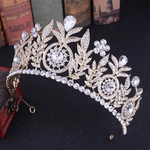 Detail of a gold bridal crown with sparkling rhinestones and crystals on a dark background