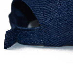 Detail of navy blue baseball cap showing adjustable hook-and-loop strap and twill texture
