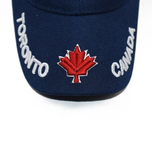 Macro shot of embroidered maple leaf and Toronto Canada text on navy baseball cap brim