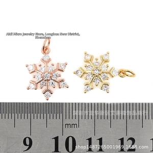 Detailed view of 15mm gold and rose gold snowflake charms with cubic zirconia and ruler