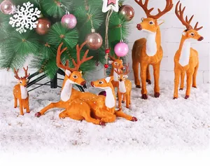 Detailed view of reindeer ornaments with brown flocking and white spots on snow
