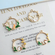 Detail of DIY jewelry pendant featuring green enamel leaves and cute white rabbit motif