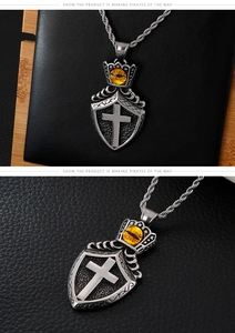Detail of vintage punk shield pendant with a crown and amber evil eye gemstone on a chain