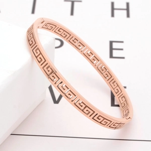 Rose gold titanium bangle with hollow geometric Great Wall pattern in a 45-degree view
