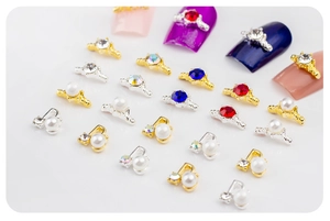 Vue macro de bijoux d'ongles dorés avec perles, strass et motifs de notes de musique