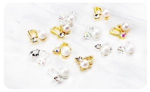 Gros plan de bijoux d'ongles en forme de D avec perles et strass sur marbre