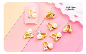 Détail de bijoux d'ongles en forme de D avec alliage doré, perle blanche et zircons