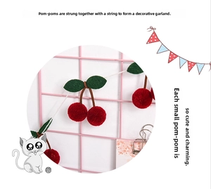 Detailed view of cherry-shaped plush balls with green leaves for home wall decoration
