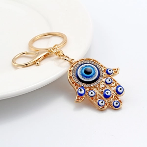 Golden Hamsa hand keychain with blue evil eye charms and sparkling rhinestones