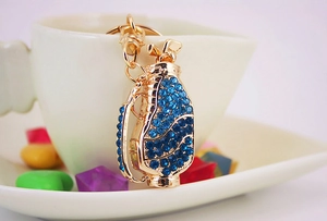 Detailed close-up of golden golf bag keychain with blue rhinestones and club charms