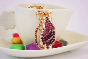 Detail of golf bag keychain with pink and purple rhinestones in a white heart cup