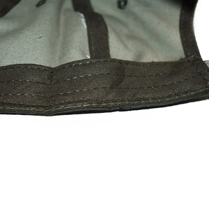 Detail of army green canvas baseball cap showing reinforced stitching and sweatband