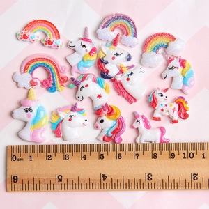 Detailed size reference for glittery resin unicorn and rainbow charms on a pink grid background