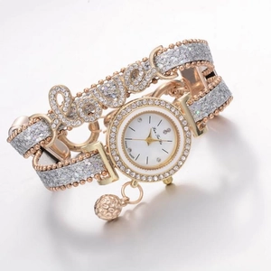 Dettaglio del cinturino in oro rosa con scritta Love in cristalli e ciondolo a sfera