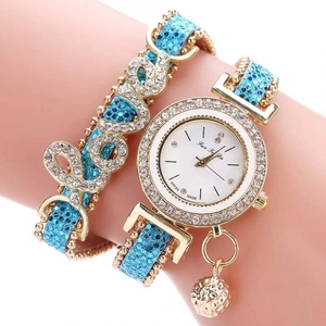 Dettaglio dell'orologio al quarzo azzurro e oro con bracciale LOVE in cristallo al polso