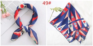 Detail of multi-color geometric print satin scarf showing smooth texture and edge stitching