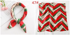 Detail of red and green striped square silk scarf with satin finish and fine red stitching