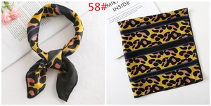 Detail of leopard print silk scarf showing tied style and flat layout with stripe accents
