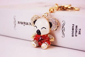 Detailed close-up of a golden koala keychain with red rhinestones on a vintage book cover