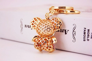 Close-up of golden metal Mickey Mouse keychain with intricate hollow clover patterns