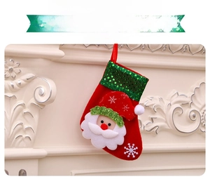 Detail of red Christmas stocking with green sequins and a 3D plush Santa Claus figure