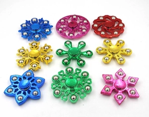Grid layout showing various metallic fidget spinners with steel bearings on white backdrop