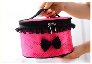 Close-up of pink polka dot makeup bag with black lace trim and bow detail