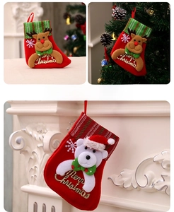Détails des chaussettes de Noël rouges avec poupées cerf et ours sur une cheminée