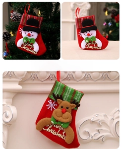 Détail de chaussettes de Noël en peluche avec bonhomme de neige 3D et renne sur cheminée