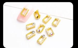 Detail showing long marquise gold alloy nail charms with pearls and rhinestones
