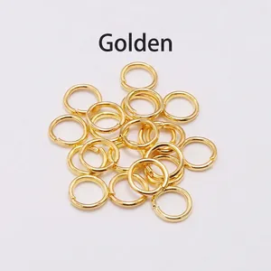 Close-up of golden jump rings DIY jewelry connectors in bulk on white background
