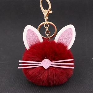 Close-up of red plush kitten keychain with pink glitter ears and gold metal clasp