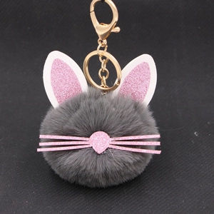 Close-up of gray plush cat keychain with pink sequin ears and gold metal clip